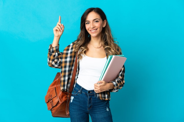 Jonge studentenvrouw die op blauwe muur wordt geïsoleerd die een geweldig idee benadrukt