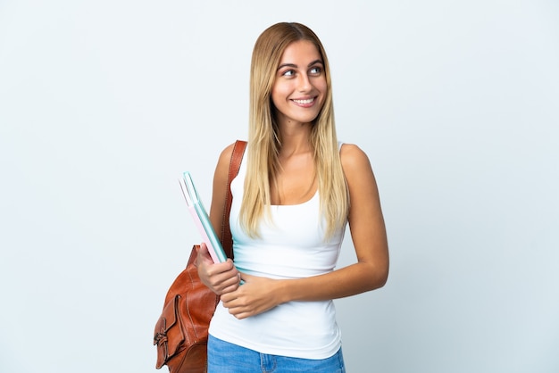 Jonge studentenvrouw die op witte achtergrond wordt geïsoleerdd die een idee denken terwijl het opzoeken