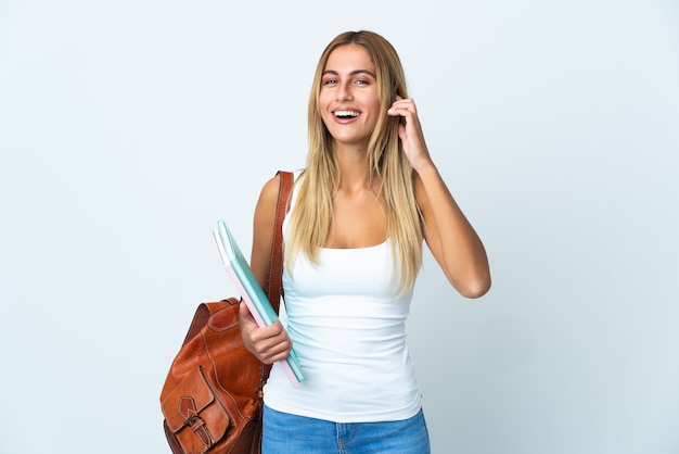 Jonge studentenvrouw die op witte muur het lachen wordt geïsoleerd