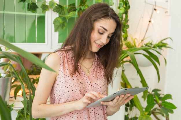 Jonge studentenvrouw die tablet thuis met behulp van