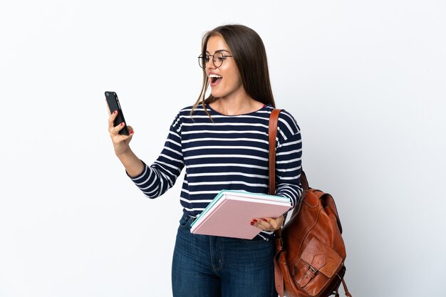 Jonge studentenvrouw geïsoleerde holdingskoffie om mee te nemen en een mobiel