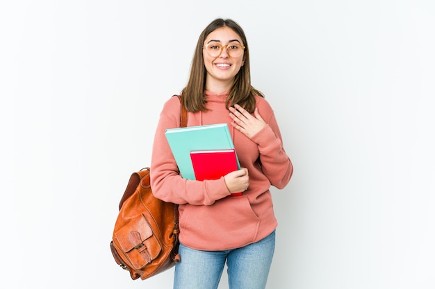 Jonge studentenvrouw heeft vriendelijke uitdrukking, handpalm tegen borst drukken