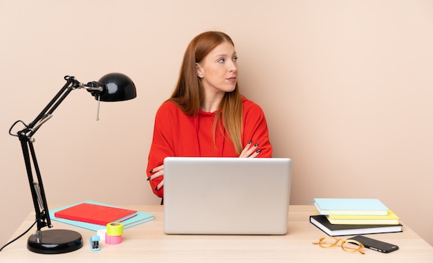 Jonge studentenvrouw op een werkplaats met een laptop portret