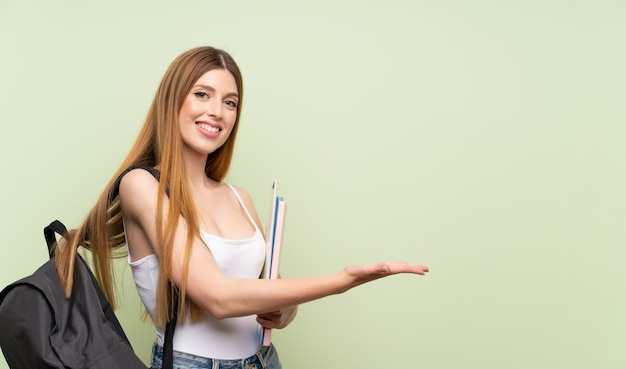 Jonge studentenvrouw op groene uitbreidende handen aan de kant voor het uitnodigen om te komen