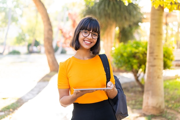 Jonge studentenvrouw wint een park met een tablet