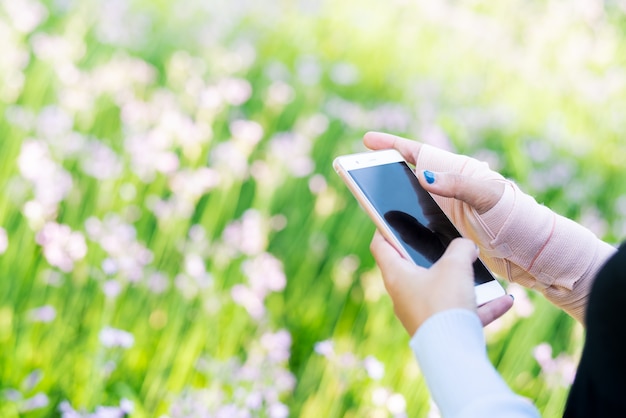 Jonge studentenvrouwen die online op smartphone winkelen terwijl de pijn van de polshand