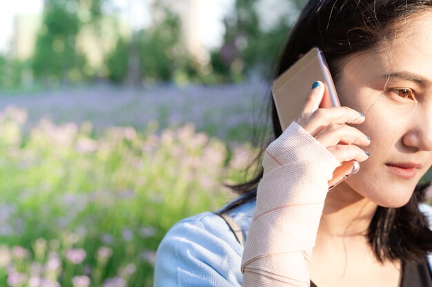 Jonge studentenvrouwen die smartphone uitnodigen terwijl de pijn van de polshand. moderne levensstijl concept