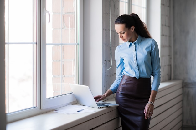 Jonge succesvolle gelukkige glimlachende bedrijfsvrouw op laptop