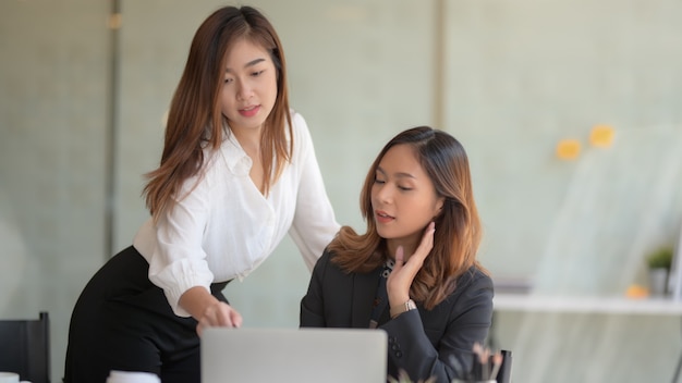 Jonge succesvolle onderneemster die op het project samen in modern bureau bespreken