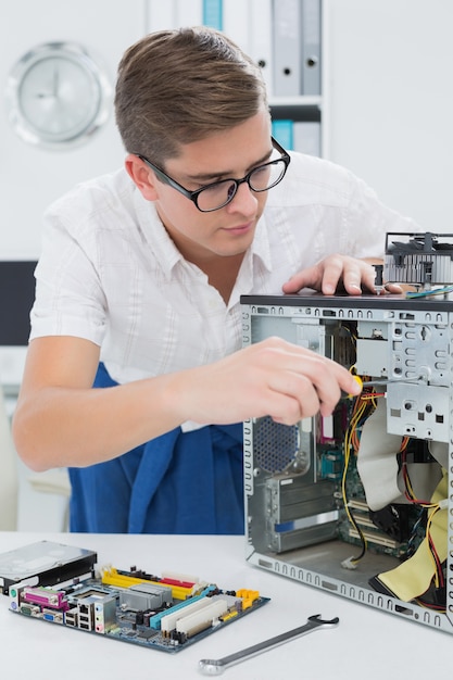 Jonge technicus die aan gebroken computer werkt