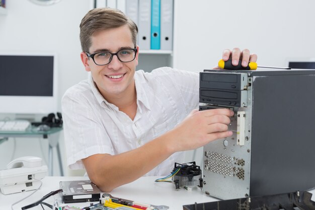 Jonge technicus die aan gebroken computer werkt