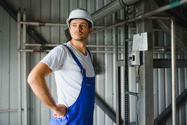 Jonge technicus met witte bouwvakker