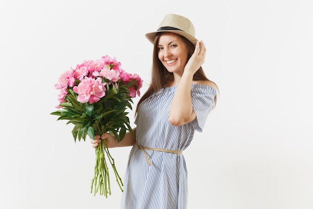 Jonge tedere vrouw in blauwe jurk, hoed met boeket van mooie roze pioenrozen bloemen geïsoleerd op een witte achtergrond. St. Valentijnsdag, Internationale Vrouwendag vakantieconcept. Reclame gebied.