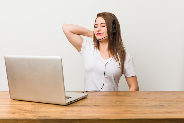 Jonge telemarketeer vrouw nekpijn lijden als gevolg van sedentaire levensstijl.