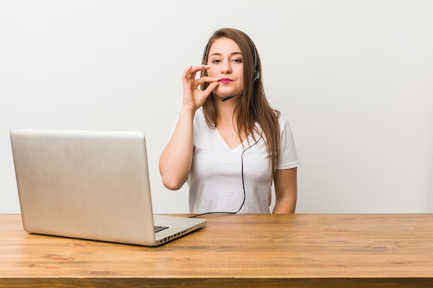 Jonge telemarketeervrouw met vingers op lippen die een geheim houden.