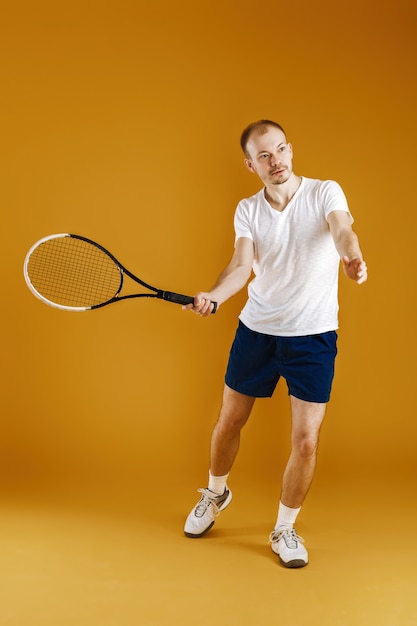 Jonge tennisser speelt tennis op een gele