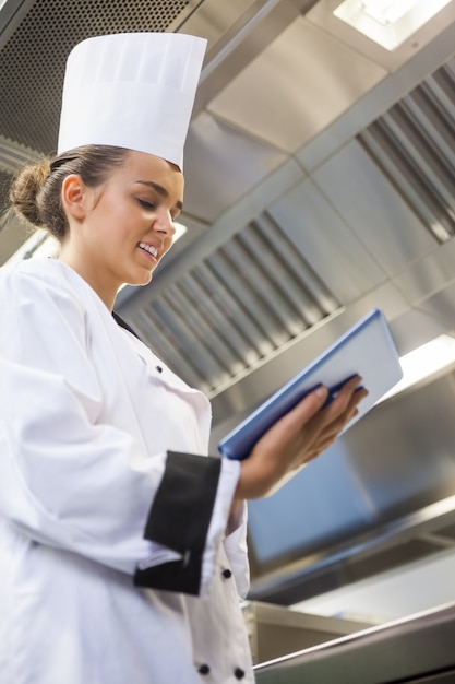 Jonge tevreden chef-kok die tablet gebruikt