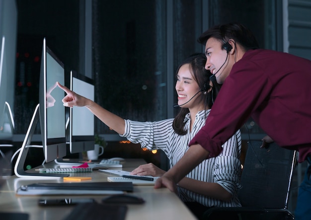 Jonge Thaise Aziatische klantenservice zorgverleners werken nachtploeg in callcenter voor het helpen van de cliënt op de werkplek 's nachts