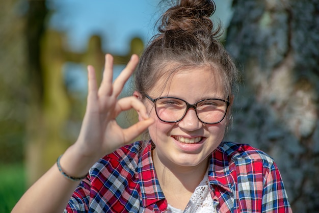 Jonge tiener die OK teken maakt