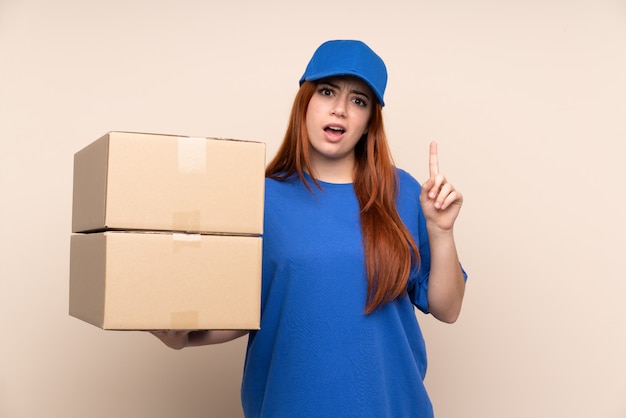 Jonge tiener levering vrouw over geïsoleerde muur wijst met de wijsvinger een geweldig idee