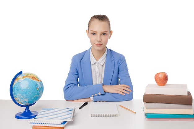 Jonge tiener vrouw zit achter het bureau met stapel boeken en globe geïsoleerd