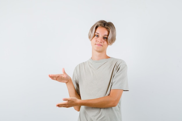 Jonge tienerjongen in t-shirt met maatbord en er vrolijk uit