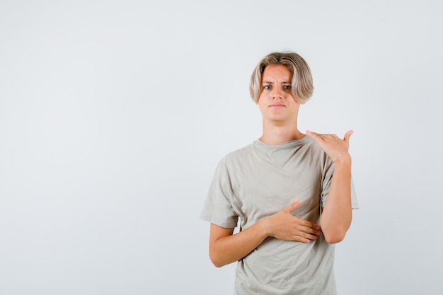 Jonge tienerjongen in t-shirt met stopgebaar en geïrriteerd, vooraanzicht.