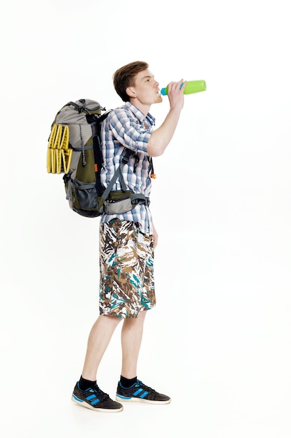 Jonge toerist met een rugzak drinkwater op een witte achtergrond