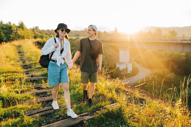 Jonge toeristen gaan hand in hand op een viaduct in de bergen