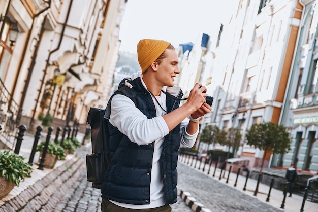 Jonge toeristenblogger loopt met camera in de oude stad