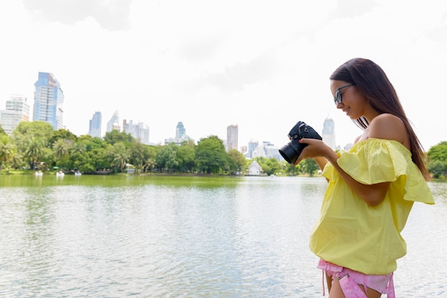 Jonge toeristenvrouw die camera in Bangkok Thailand met behulp van