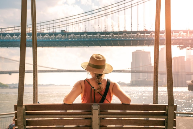 Jonge toeristische vrouw op de Brooklyn Bridge en Manhattan Bridge. New York city solo reiziger in de VS.