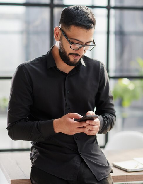 Jonge toevallige Zakenmanholding en het gebruiken van smartphone voor smsberichten