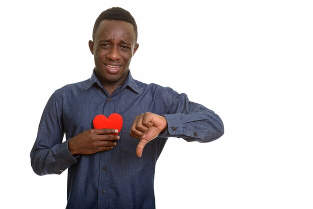Jonge triest Afrikaanse man met rood hart op de borst