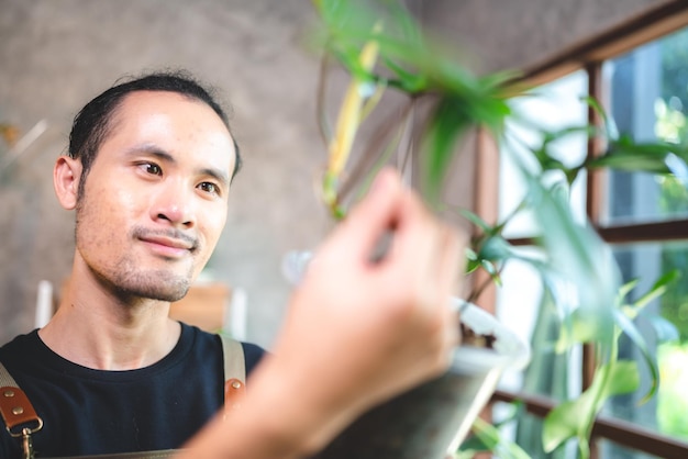 Jonge tuinieren een plant in hobby thuis natuur bloemist persoon levensstijl in groen concept