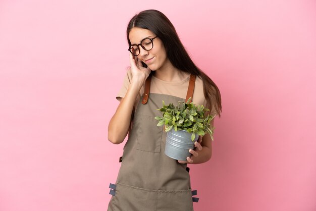 Jonge tuinman meisje met een plant geïsoleerd holding