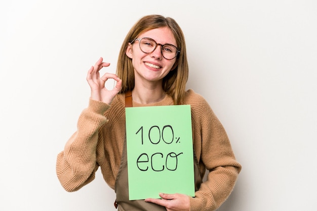 Jonge tuinman vrouw met een 100 eco plakkaat geïsoleerd op een witte achtergrond vrolijk en zelfverzekerd met ok gebaar