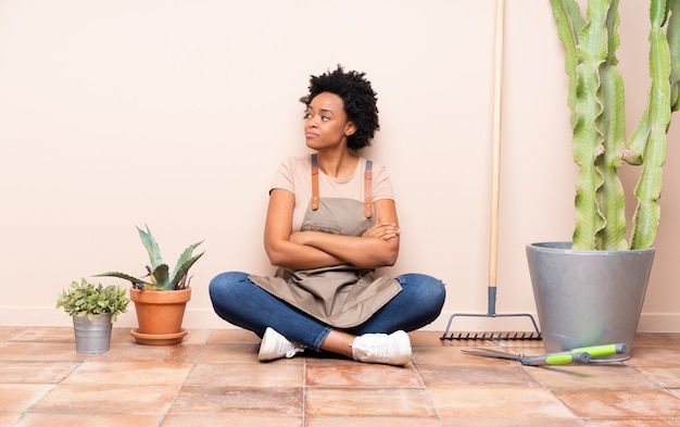 Jonge tuinman vrouw zittend op de vloer