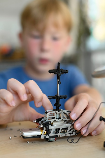 Jonge uitvinder die zorgvuldig robotspeelgoed in elkaar zet en werkt met kleine mechanische onderdelen