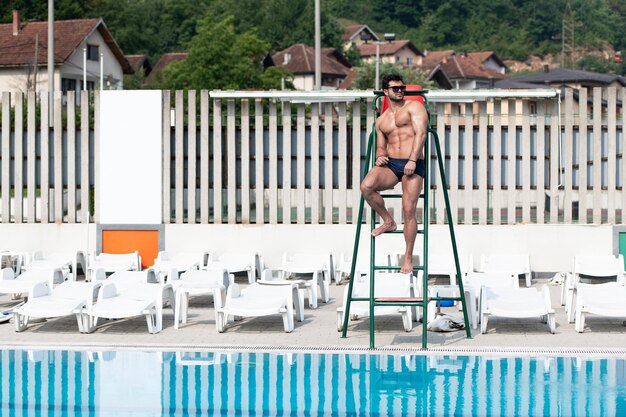 Jonge uitziende badmeester Man bij het zwembad buiten