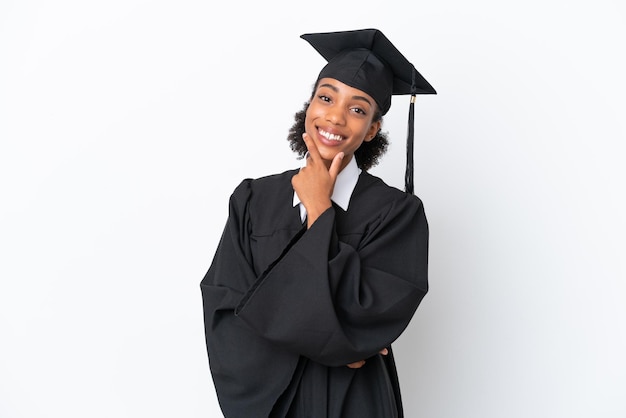 Jonge universitair afgestudeerde Afro-Amerikaanse vrouw geïsoleerd op een witte achtergrond lachend