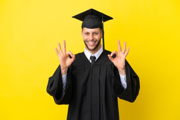 Jonge universitair afgestudeerde blanke man geïsoleerd op gele achtergrond met een ok-teken met vingers