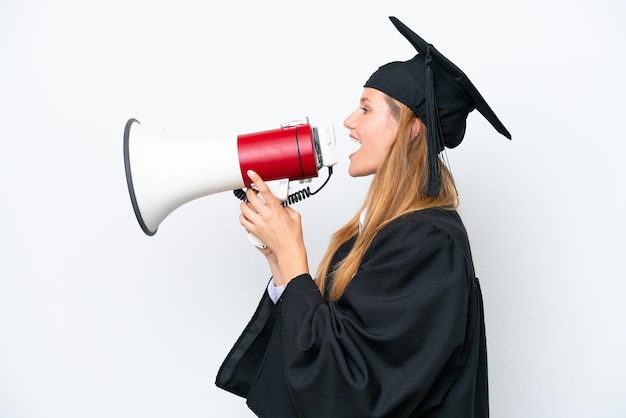 Jonge universitair afgestudeerde blanke vrouw geïsoleerd op een witte achtergrond schreeuwen door een megafoon