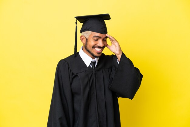 Jonge universitair afgestudeerde Colombiaanse man geïsoleerd op gele achtergrond lachen