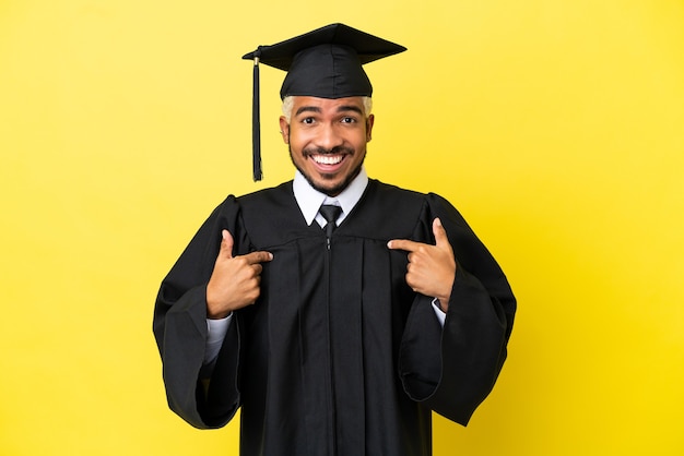 Jonge, universitair afgestudeerde Colombiaanse man geïsoleerd op gele achtergrond met verrassende gezichtsuitdrukking