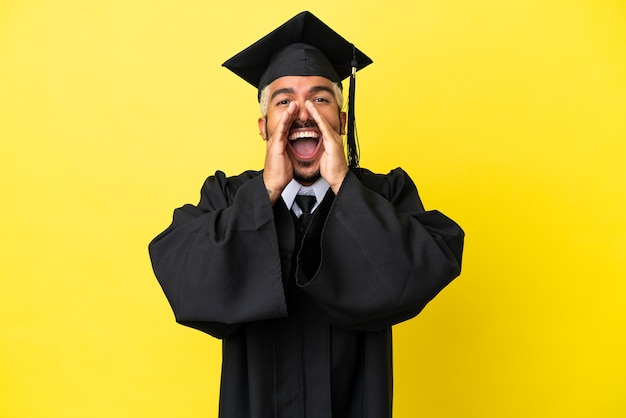 Jonge, universitair afgestudeerde Colombiaanse man geïsoleerd op gele achtergrond schreeuwen en iets aankondigen