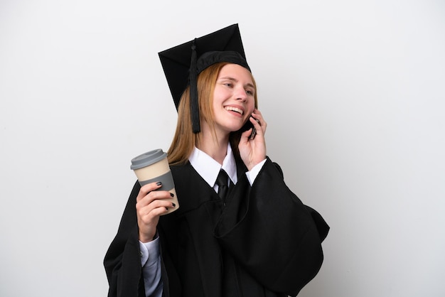 Jonge universitair afgestudeerde Engelse vrouw geïsoleerd op een witte achtergrond met koffie om mee te nemen en een mobiel