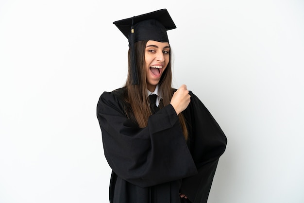 Jonge universitair afgestudeerde geïsoleerd op een witte achtergrond die een overwinning viert