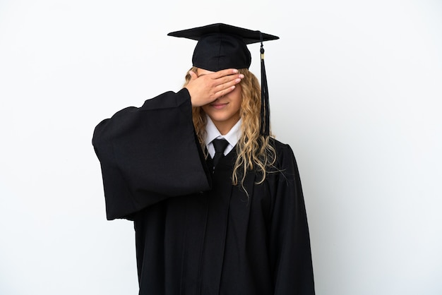 Jonge universitair afgestudeerde geïsoleerd op een witte achtergrond die ogen bedekt door handen. Wil je iets niet zien