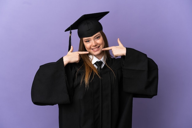 Jonge universitair afgestudeerde over geïsoleerde paarse achtergrond met een duim omhoog gebaar